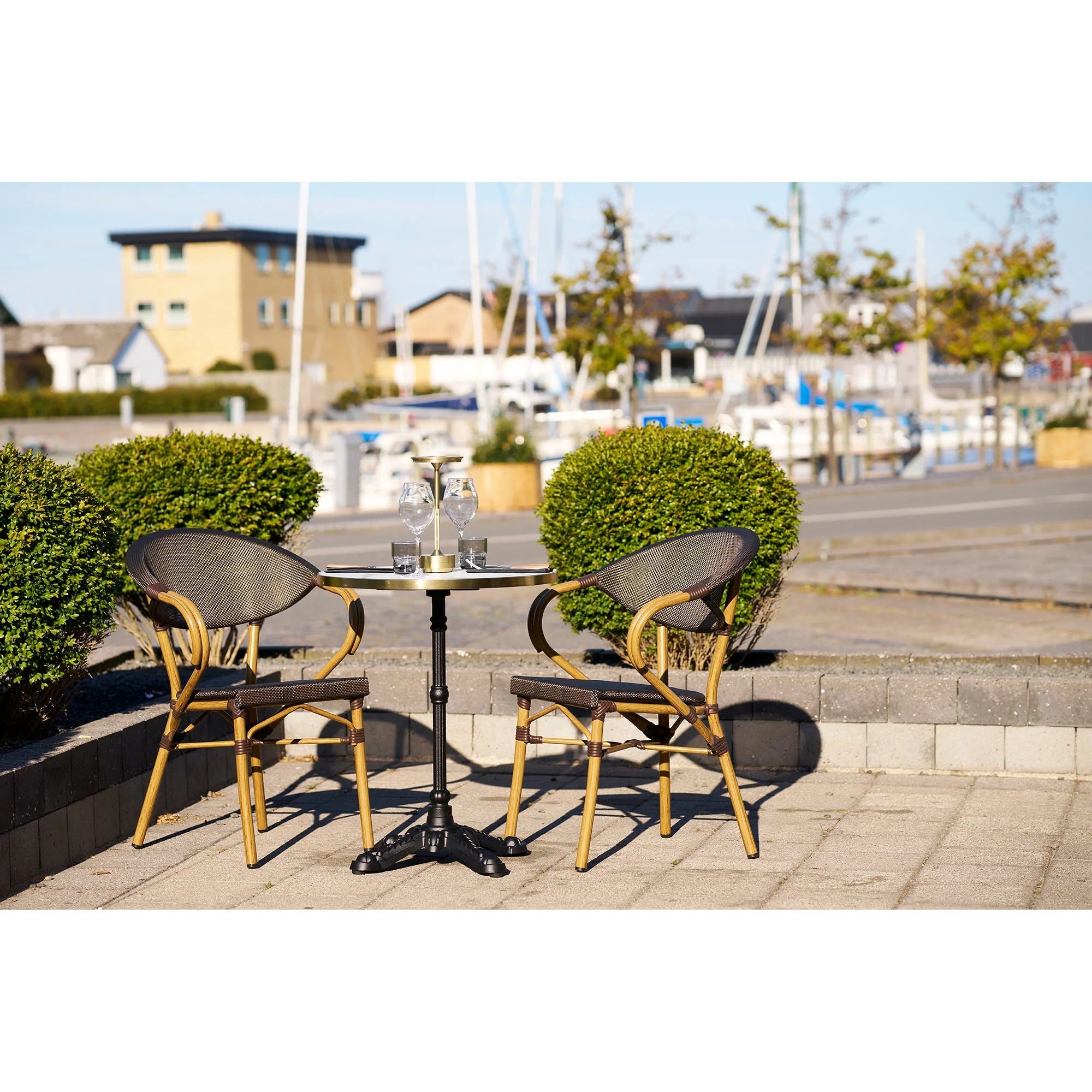 Table bistrot ronde effet marbre blanc bord doré pied noir Ø60 cm avec chaises osier ton or