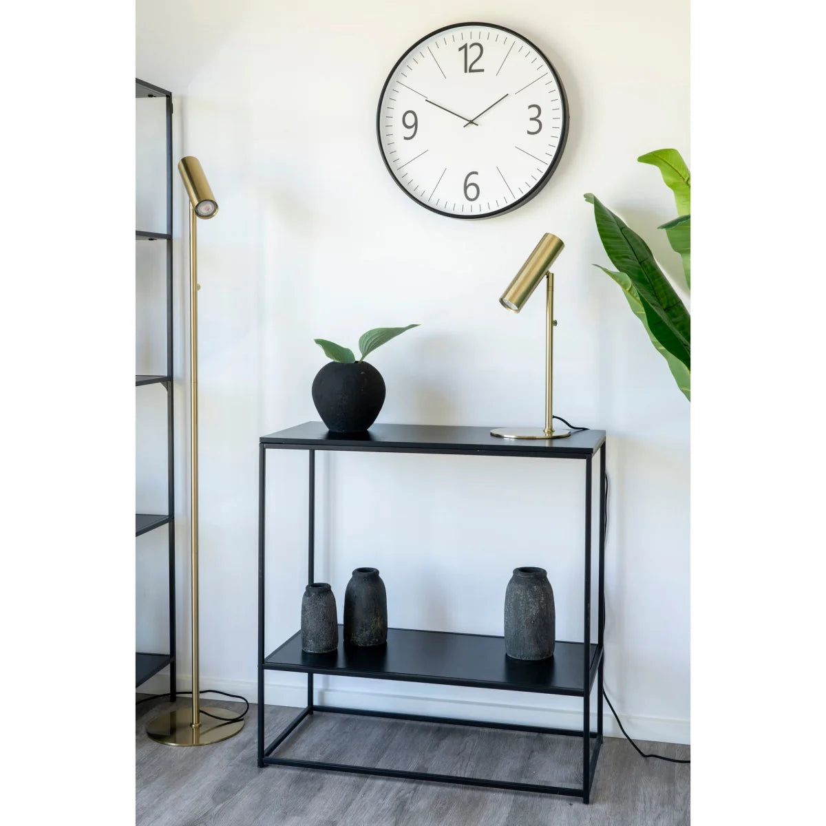 Table console noire minimaliste en métal avec étagères et vases