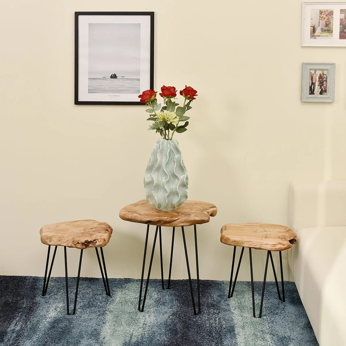 Vase en céramique bleu clair avec roses rouges et fleurs blanches sur table en bois et métal