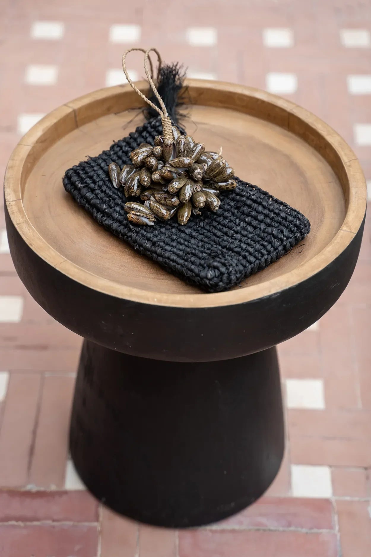 Pochette noire tissée avec embellissements en perles sur la table dappoint en bois suar noir