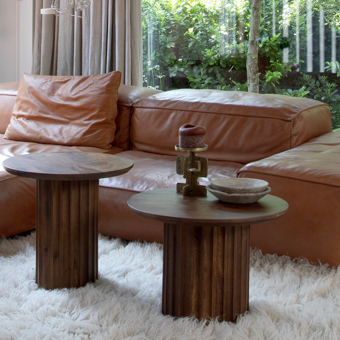 Deux tables d’appoint rondes en bois brun avec pieds colonnes cannelés sur tapis blanc Ø50 cm