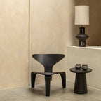 Chaise minimaliste noire avec design sculptural et finition mate lisse