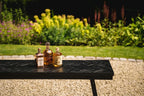 Trois bouteilles de liqueur sur la table haute à chevrons noire 140 cm