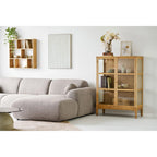 Canapé sectionnel en tissu gris clair texturé avec accoudoirs ronds et ottomane