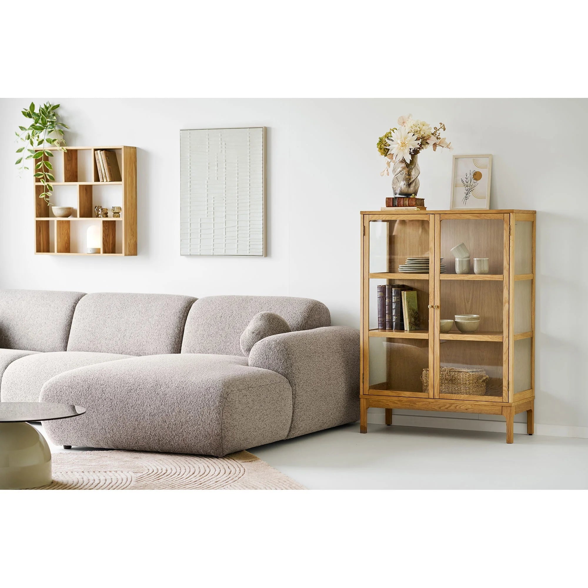 Canapé sectionnel en tissu gris clair texturé avec accoudoirs ronds et ottomane