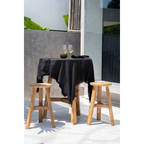 Nappe en lin noir aux bords effilochés sur tabourets en teck recyclé H66 cm