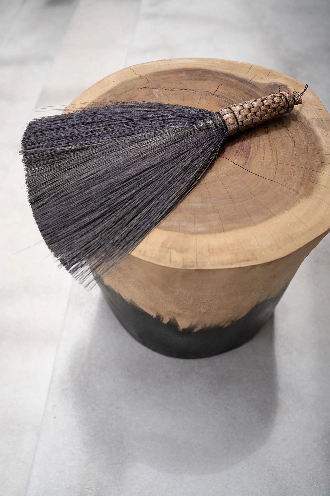 Balayette en gris avec manche courte sur tabouret en bois de Suar bicolore noir et naturel