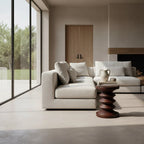 Canapé sectionnel en tissu beige texturé avec coussins et table en bois sculpté