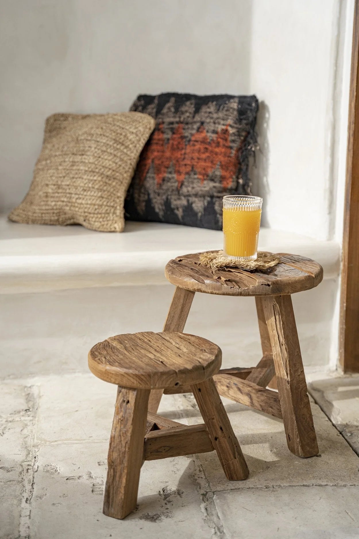 Tabouret rond en teck recyclé naturel avec des verres de jus d’orange