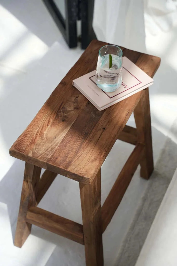 Tabouret rustique Fab Naturel avec livre et verre d’eau sur le dessus