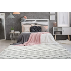 Tapis à motifs losanges blanc et gris en polyester doux dans une chambre cosy