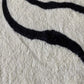 Zoom sur les motifs géométriques du tapis bohème noir et blanc