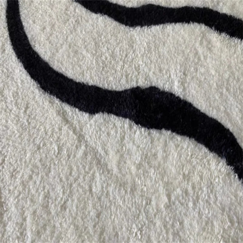 Zoom sur les motifs géométriques du tapis bohème noir et blanc