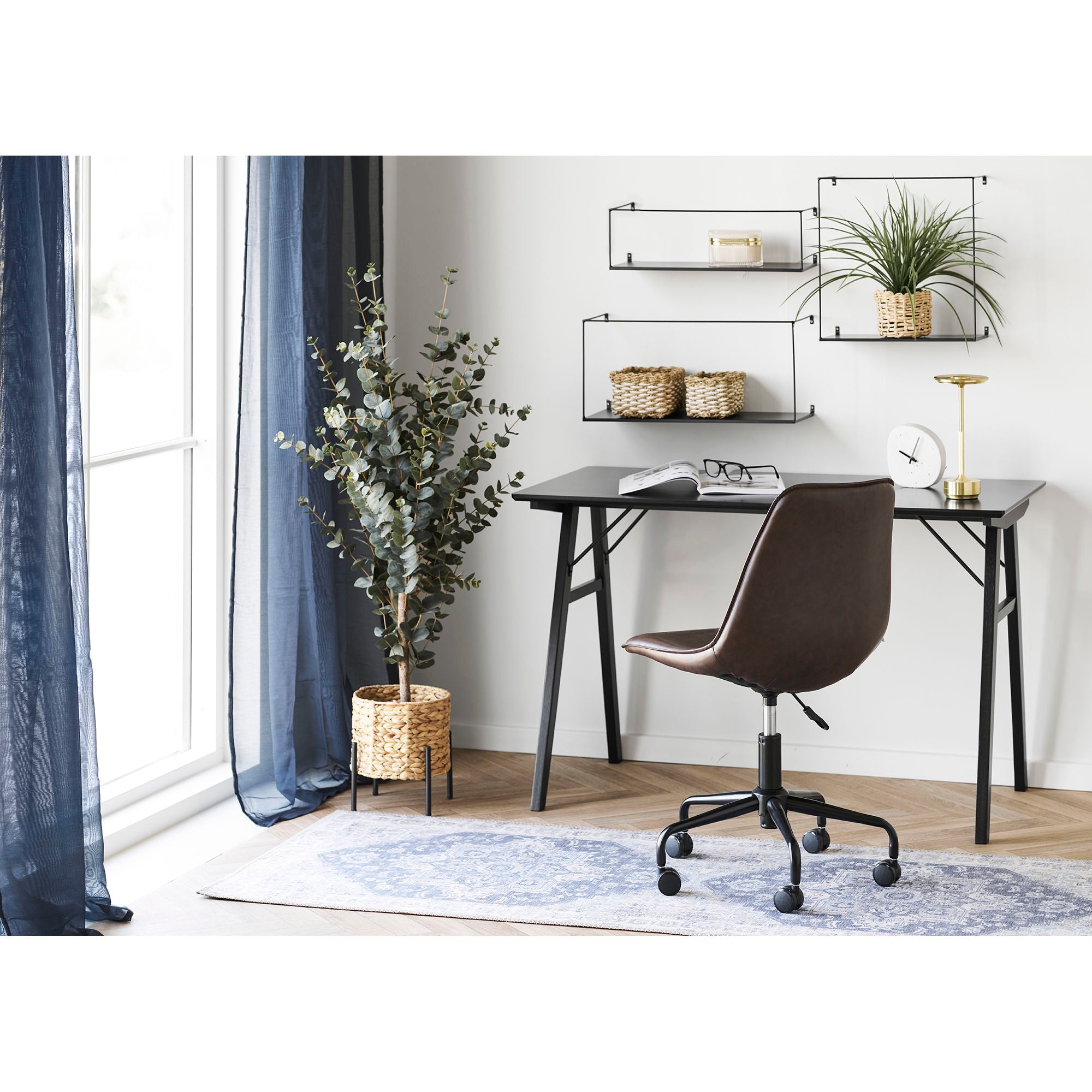 Bureau noir minimaliste aux pieds métalliques contre mur blanc, tapis persan bleu 80x200 cm