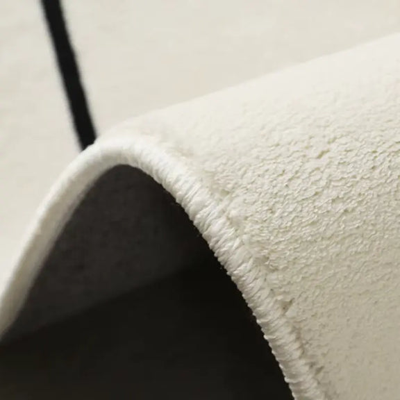Gros plan sur la texture douce et épaisse du tapis forme asymétrique noir et blanc.
