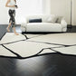 Tapis noir et blanc installé dans un salon chic avec mobilier contemporain et lumière naturelle.