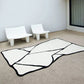 Tapis noir et blanc en forme asymétrique utilisé pour un décor extérieur sur une terrasse.