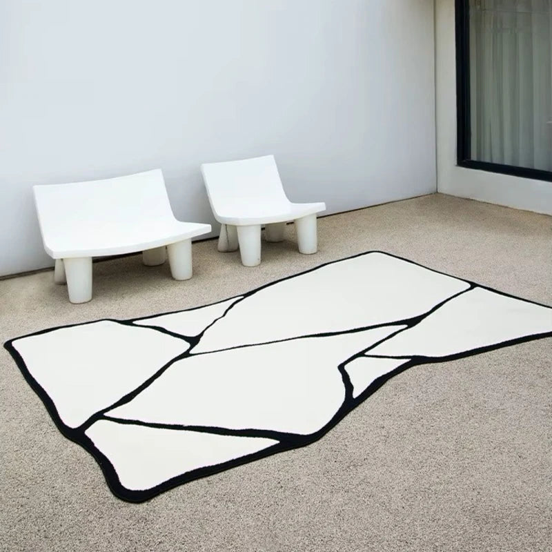 Tapis noir et blanc en forme asymétrique utilisé pour un décor extérieur sur une terrasse.