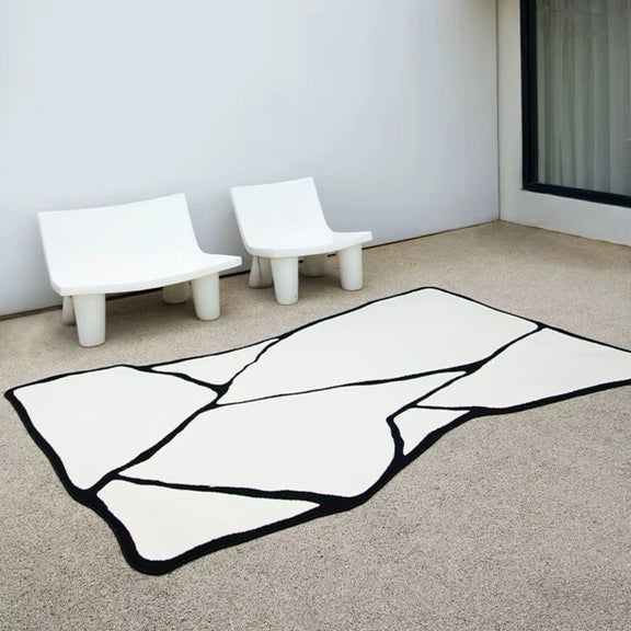 Tapis noir et blanc en forme asymétrique utilisé pour un décor extérieur sur une terrasse.