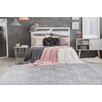 Lit avec tête de lit blanche, literie rose et grise, coussin nœud décoratif