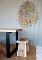 Tapis en jonc d’eau naturel avec franges sur une table et banquette en bois rustique