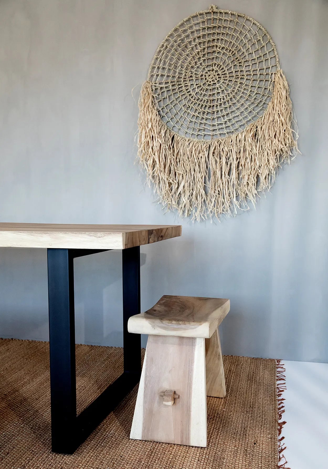 Tapis en jonc d’eau naturel avec franges sur une table et banquette en bois rustique