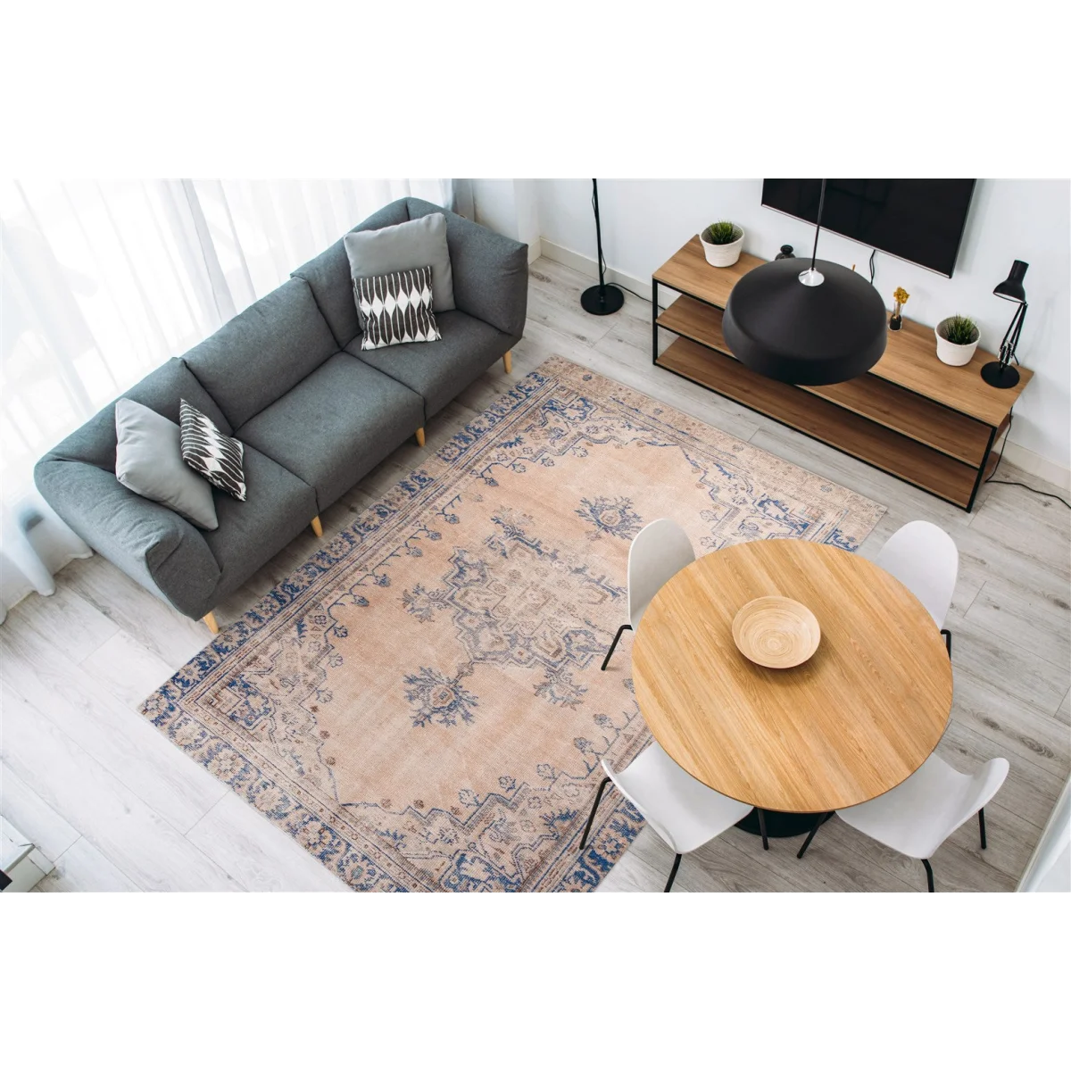 Vue aérienne d’un salon moderne avec tapis oriental rose poudré à motifs bleus