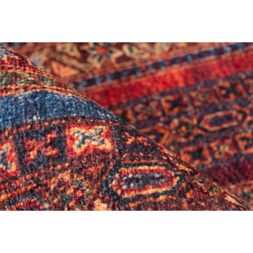 Tapis oriental richement motifé plié avec des nuances de rouge, bleu et orange