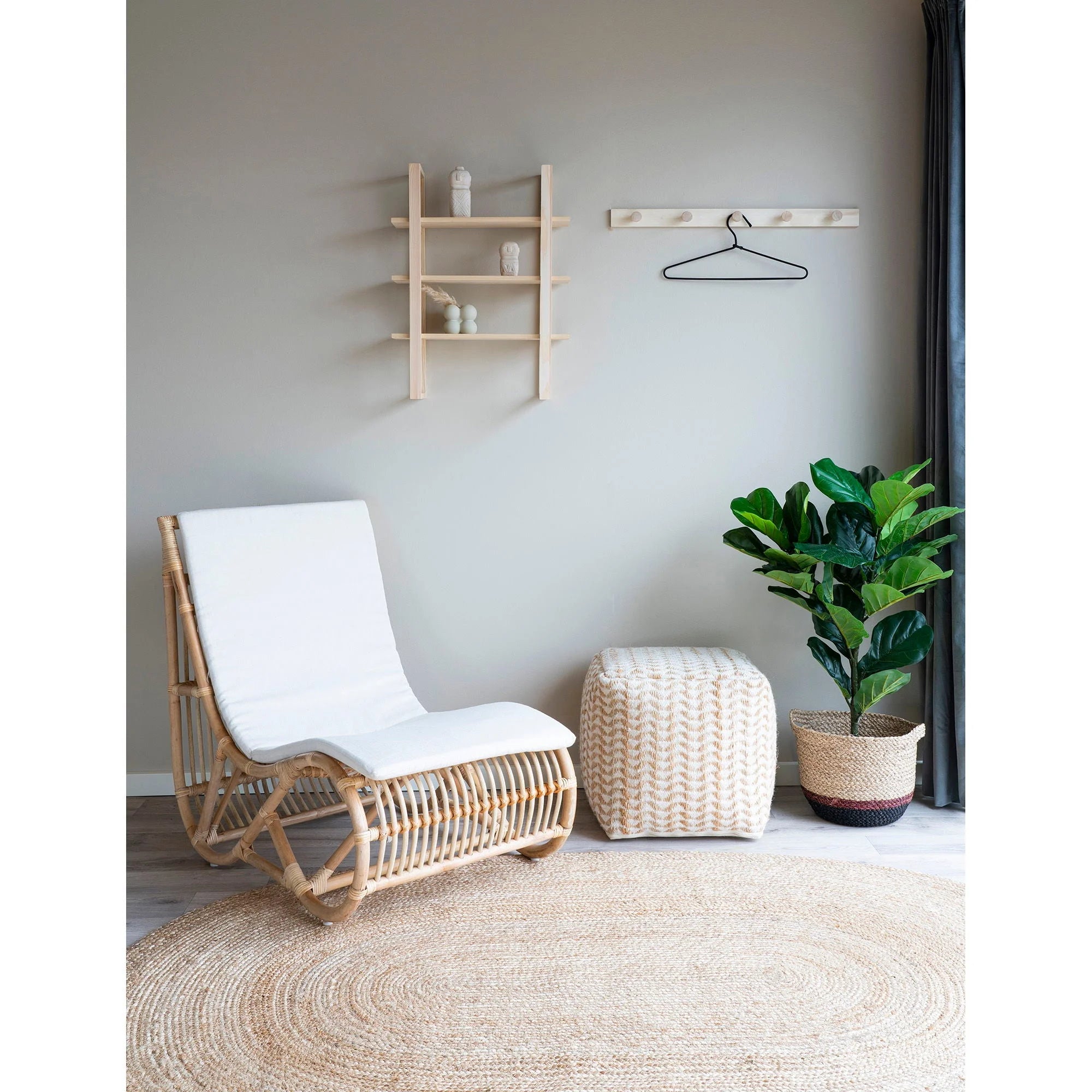 Chaise en osier avec coussins blancs sur tapis ovale en jute naturelle 140x200 cm