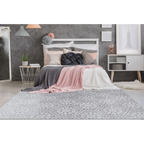 Lit avec tête de lit blanche, literie rose et grise, coussin nœud décoratif