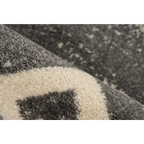 Vue rapprochée d’un tapis rectangulaire gris avec motifs ethniques et texture douce