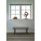 Banquette rembourrée avec pieds noirs dans le salon, Tapis rectangulaire en jute et laine