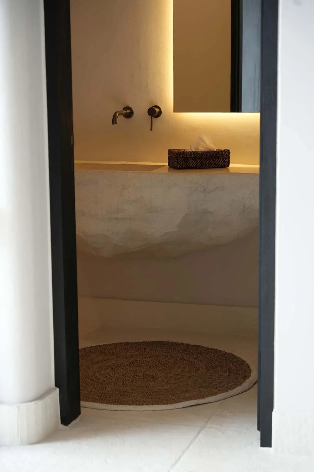 Intérieur de salle de bain moderne avec tapis rond en jonc de mer et coton blanc naturel