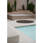 Espace détente extérieur avec banquette, fontaine rocheuse et piscine, Tapis rond en jonc de mer noir 150 cm