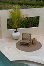 Chaise en osier et table d’appoint sur un tapis rond en jonc de mer tressé