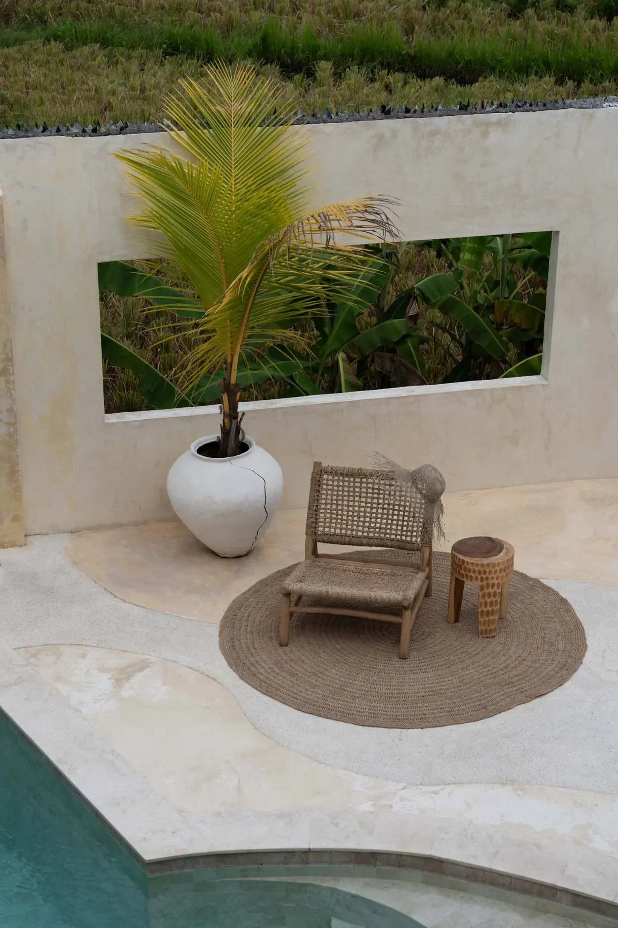 Chaise en osier et table d’appoint sur un tapis rond en jonc de mer tressé