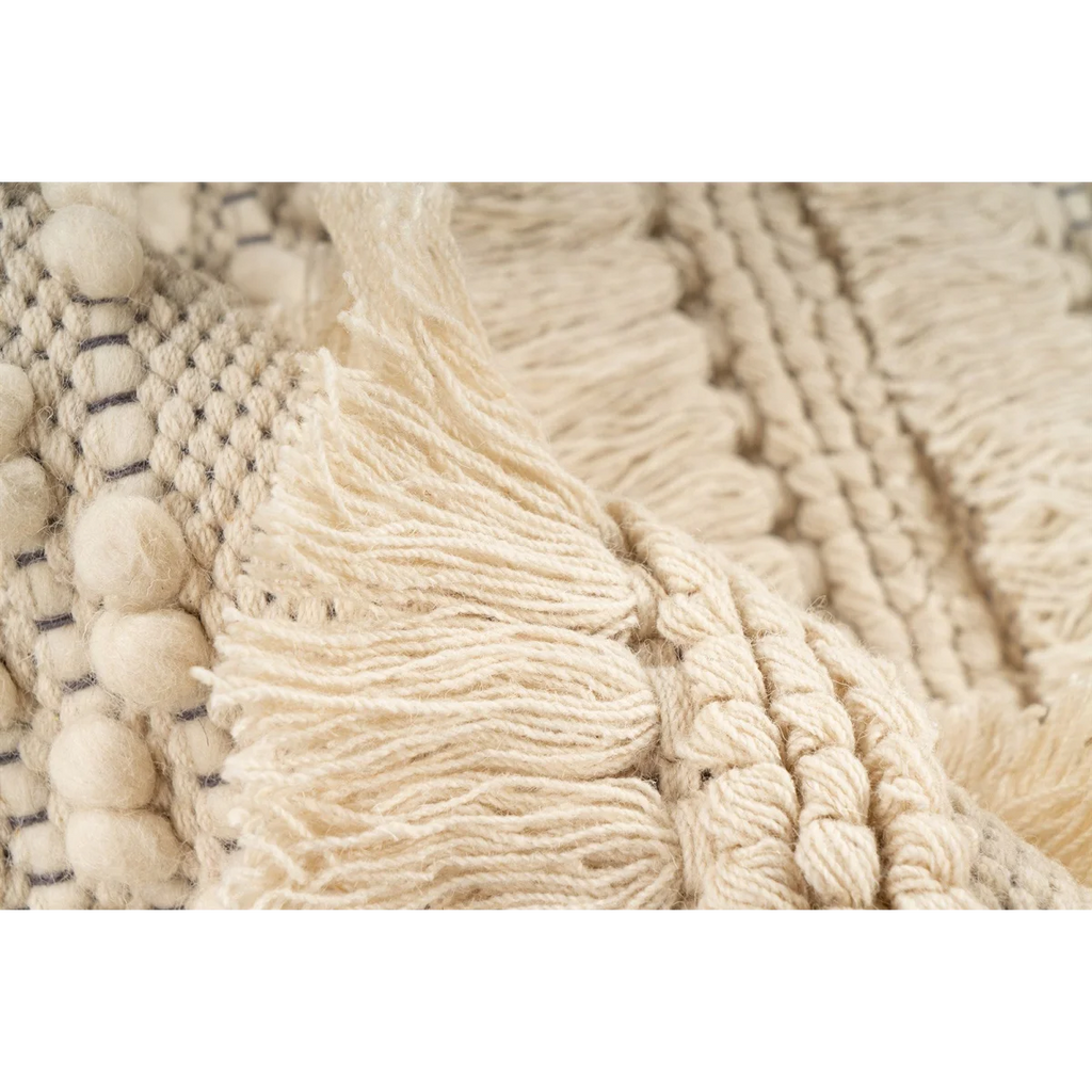 Tapis rond en laine écrue avec franges et relief tressé, textile crème texturé