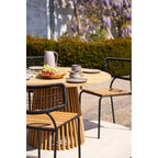 Table ronde bois naturel Ø180 cm, pieds bambou, chaises métal tressées sable recyclé