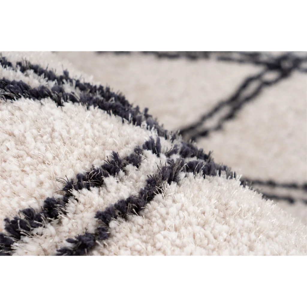 Tapis shaggy rectangulaire écru avec motifs losanges noirs et texture shaggy blanche et grise