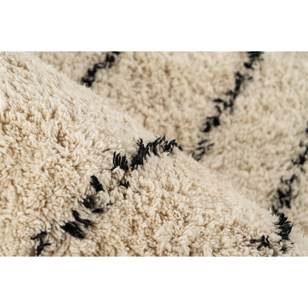 Tapis tufté écru avec motifs noirs en coton et franges, vue en gros plan
