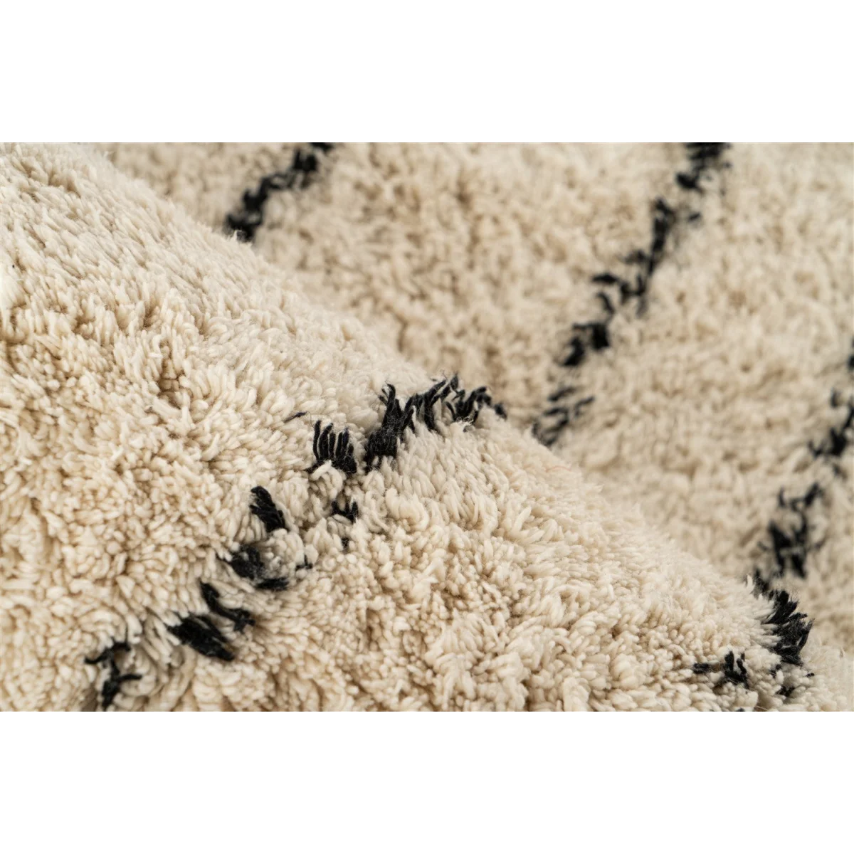 Tapis tufté écru avec motifs noirs en coton et franges, vue en gros plan