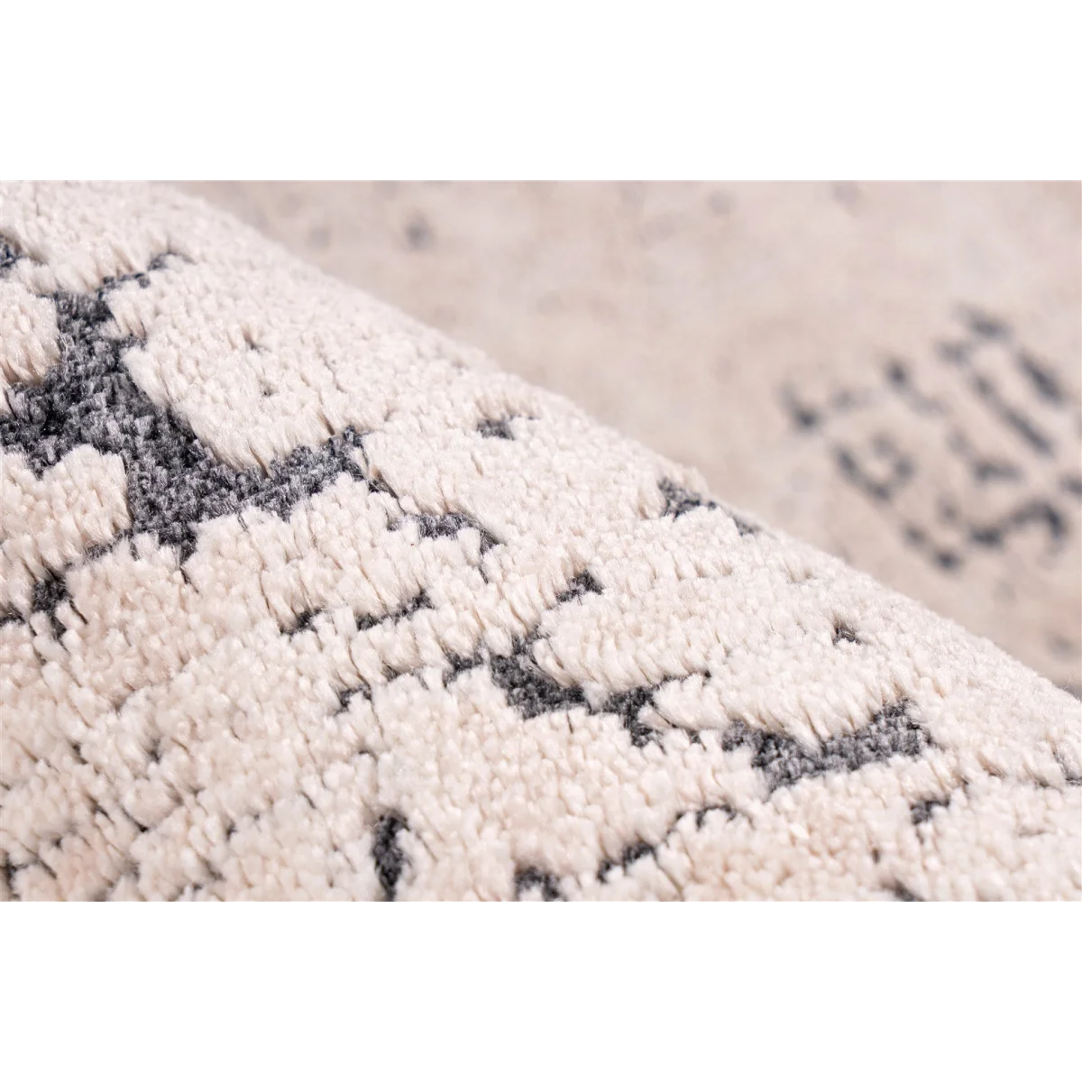 Zoom sur un tapis vintage écru et anthracite avec motifs géométriques abstraits