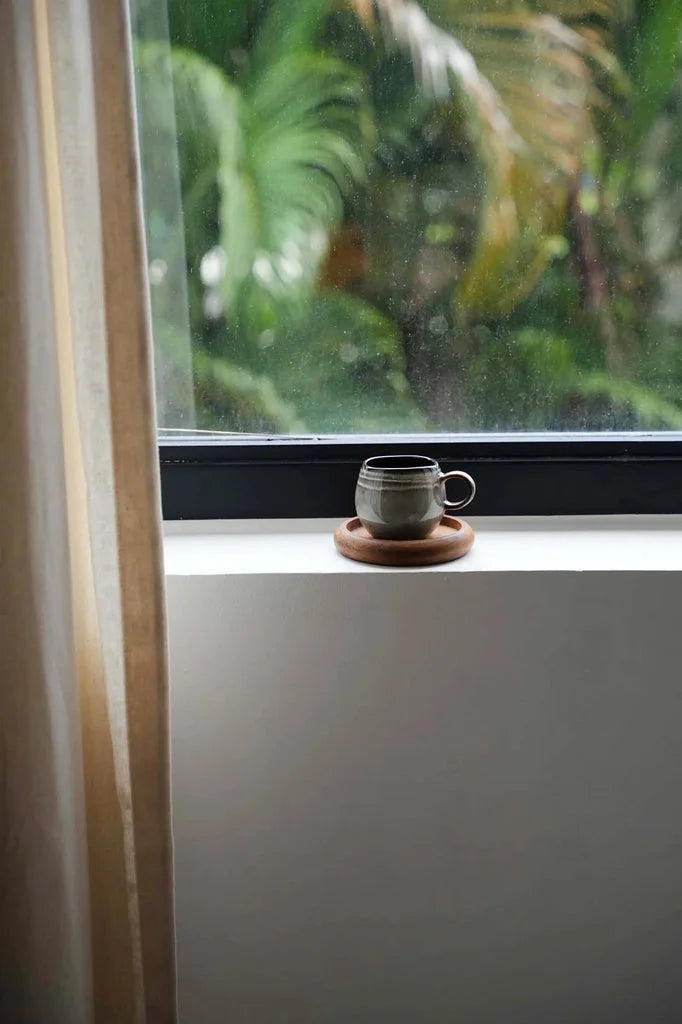Tasse à espresso en céramique sur un sous-verre en bois dans l’ensemble Comporta S