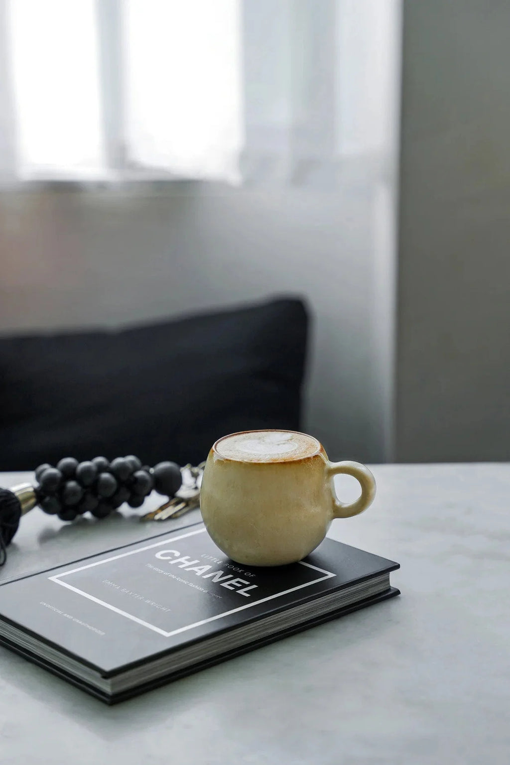Tasse à espresso en céramique beige doré sur livre Chanel noir