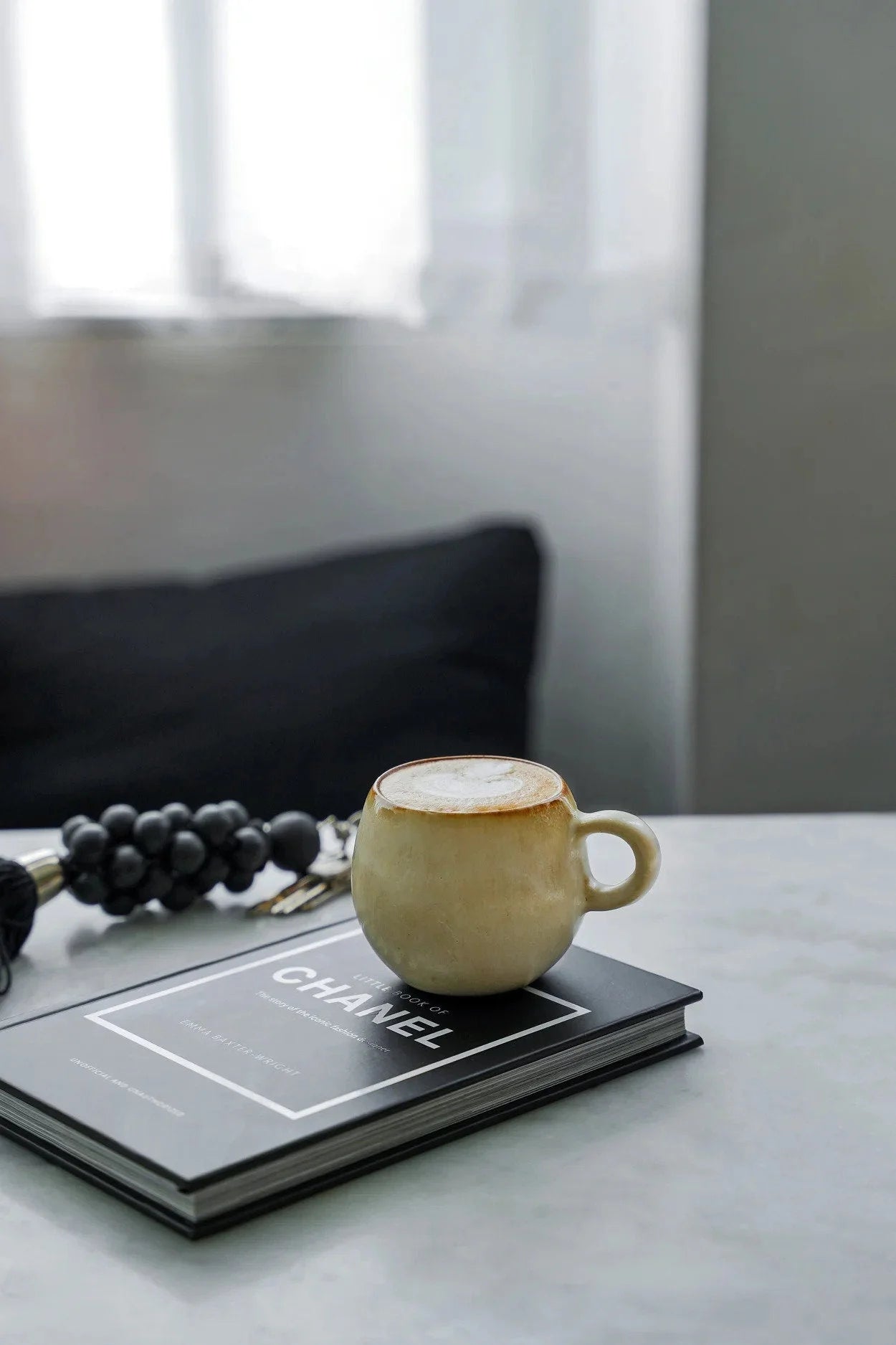 Tasse à espresso en céramique beige doré sur livre Chanel noir