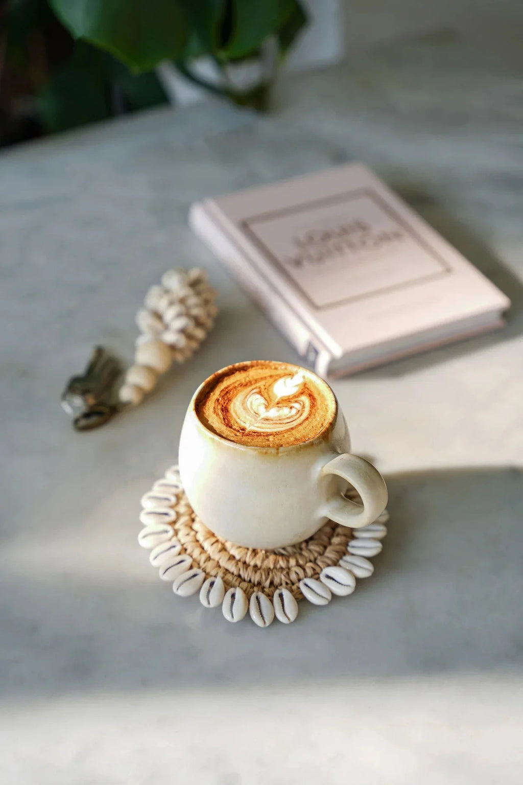 Tasse en céramique blanc cassé avec rebord doré, art latte délicat