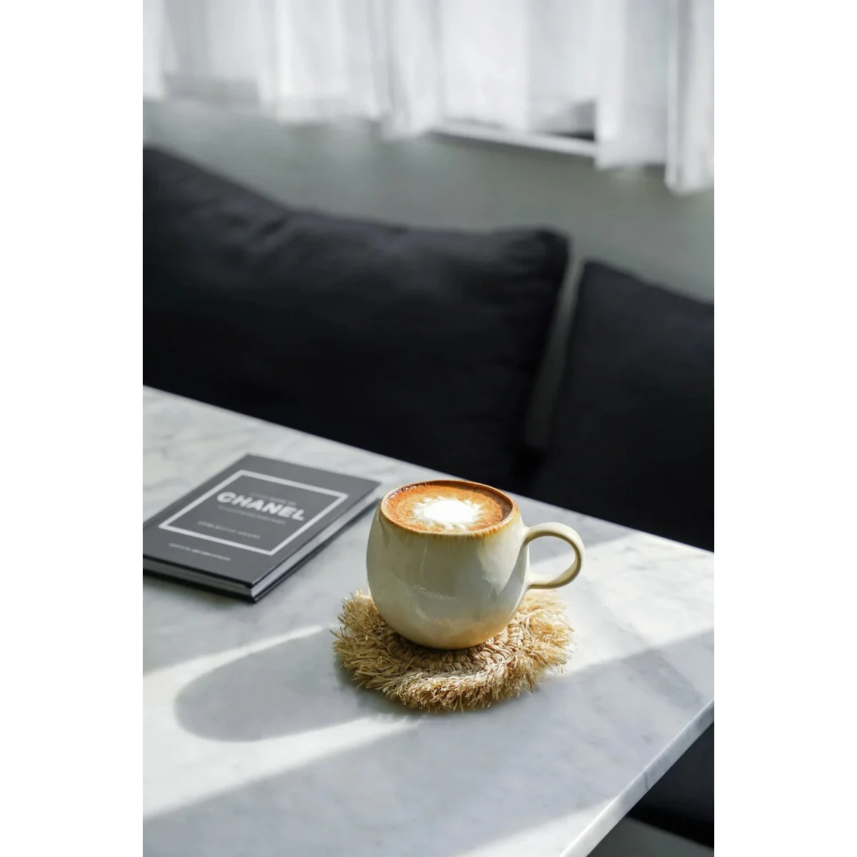 Tasses en céramique arrondies beiges avec latte art sur un dessous de tasse en rotin