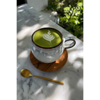Tasse en céramique artisanale gris-vert à bandes texturées avec un matcha latte art