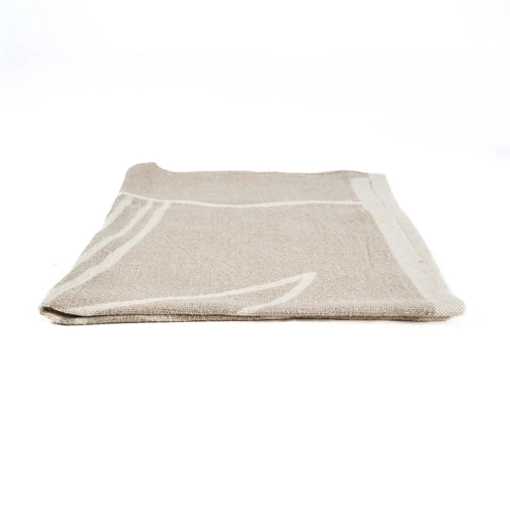 Torchon en lin naturel beige plié, motif palmier blanc cassé texturé
