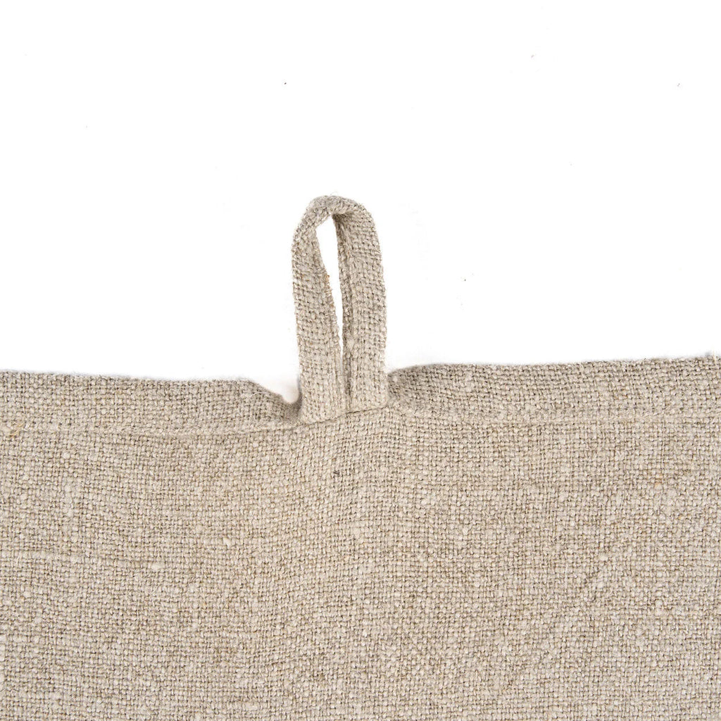 Torchon en lin naturel motif palmier blanc cassé plié avec texture tissée et fines rayures noires horizontales sur le bord